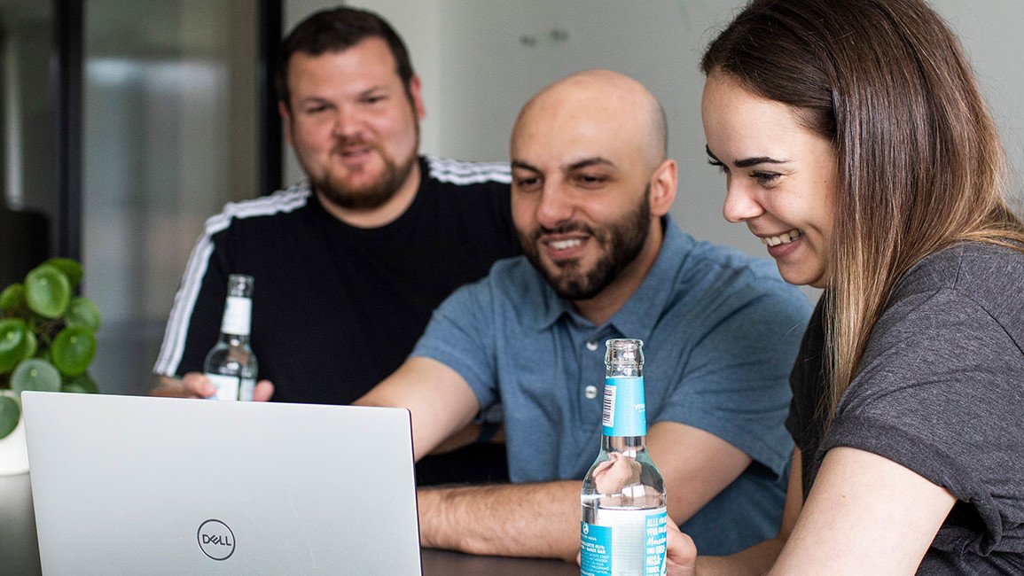 Content Marketing Beispiele: Drei mindshape-Mitarbeiter:innen schauen auf Laptop