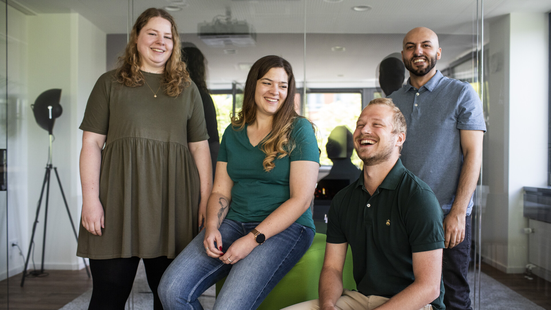 mindshape-Benefits: Wir agieren im Team. mindshape-Benefits: Ein Team sitzt und steht lächelnd zusammen im Forum.