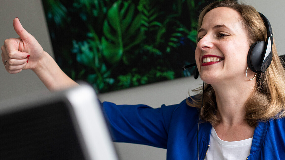 Frau sitzt lächelnd im Büro