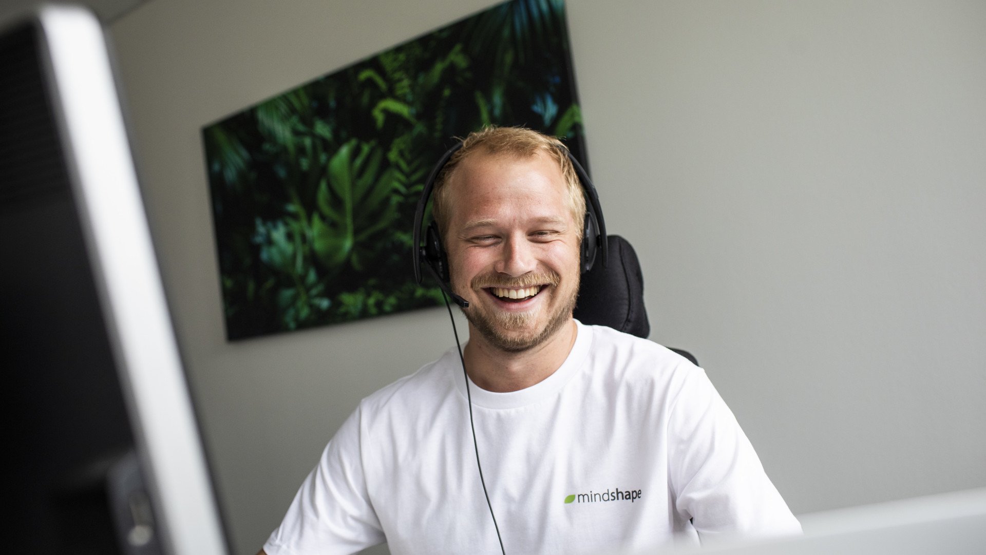 mindshape-Benefits: Digitale Kommunikation gehört zum Arbeitsalltag. mindshape-Benefits: Eine Person im Videocall mit Headset auf dem Kopf.