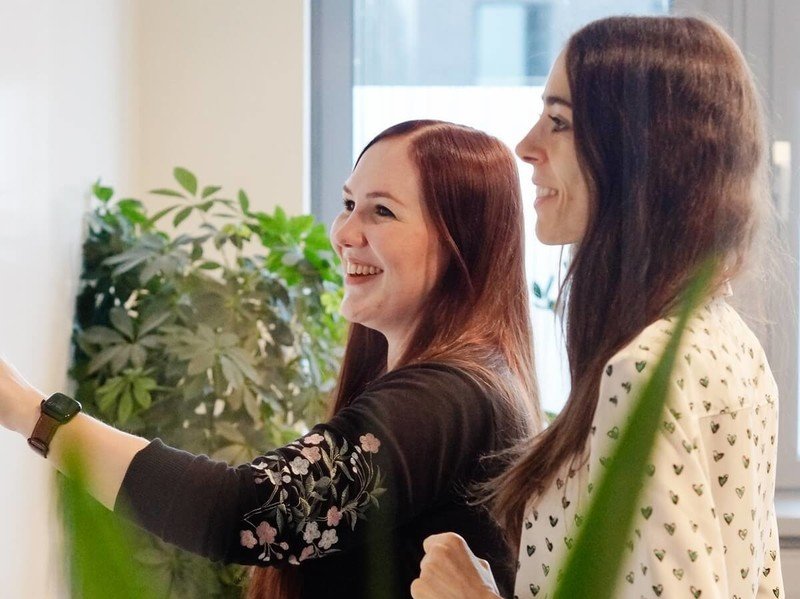 Zusammenarbeit bei mindshape Zwei Frauen stehen am Whiteboard und arbeiten zusammen