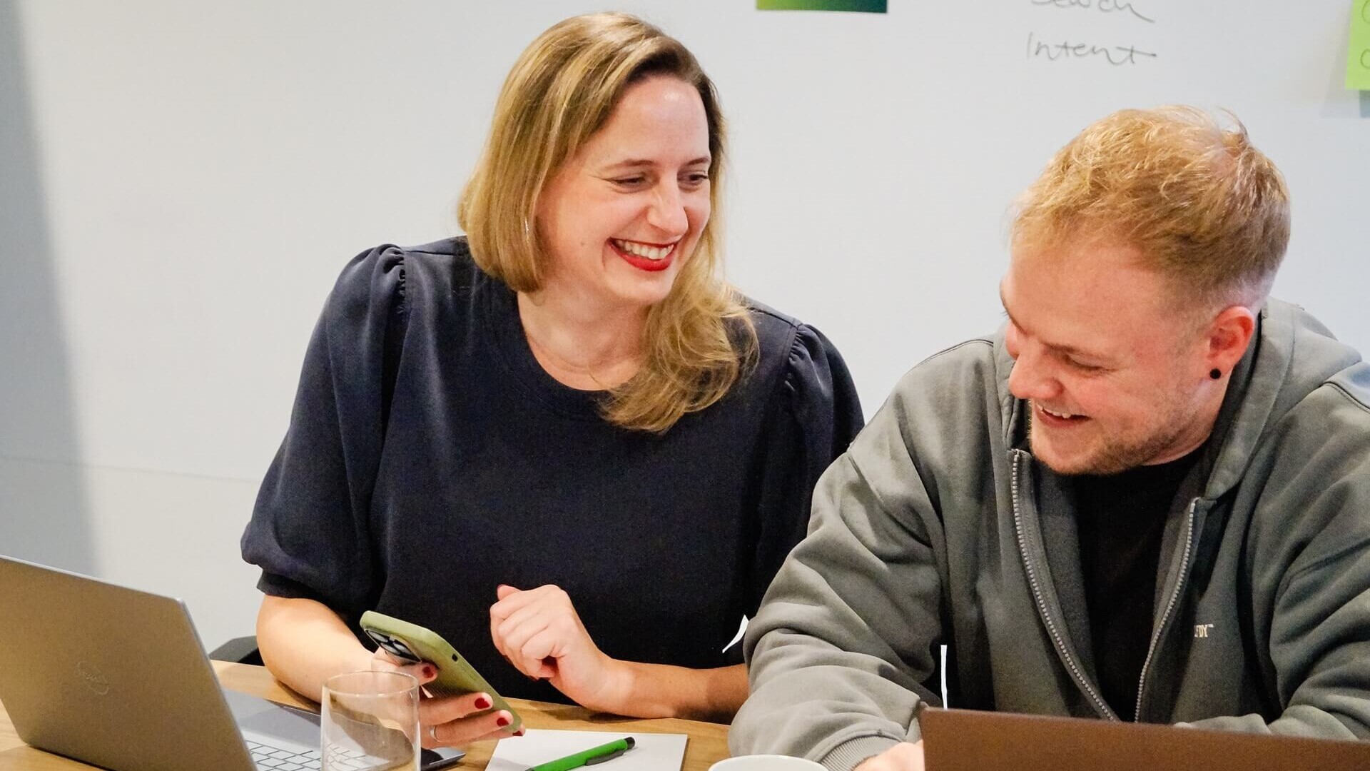 mindshape Team Zwei Mitarbeitende von mindshape sitzen lachend am Tisch