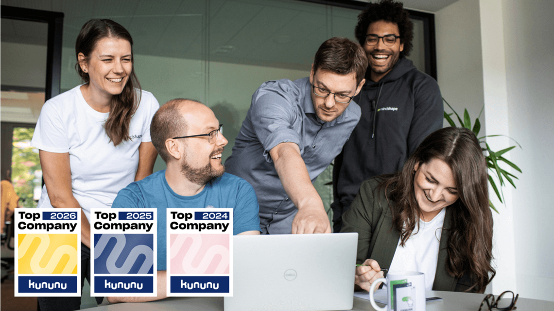 mindshape ist Kununu Top Company mindshapees schauen auf einen Laptop im Meeting Raum