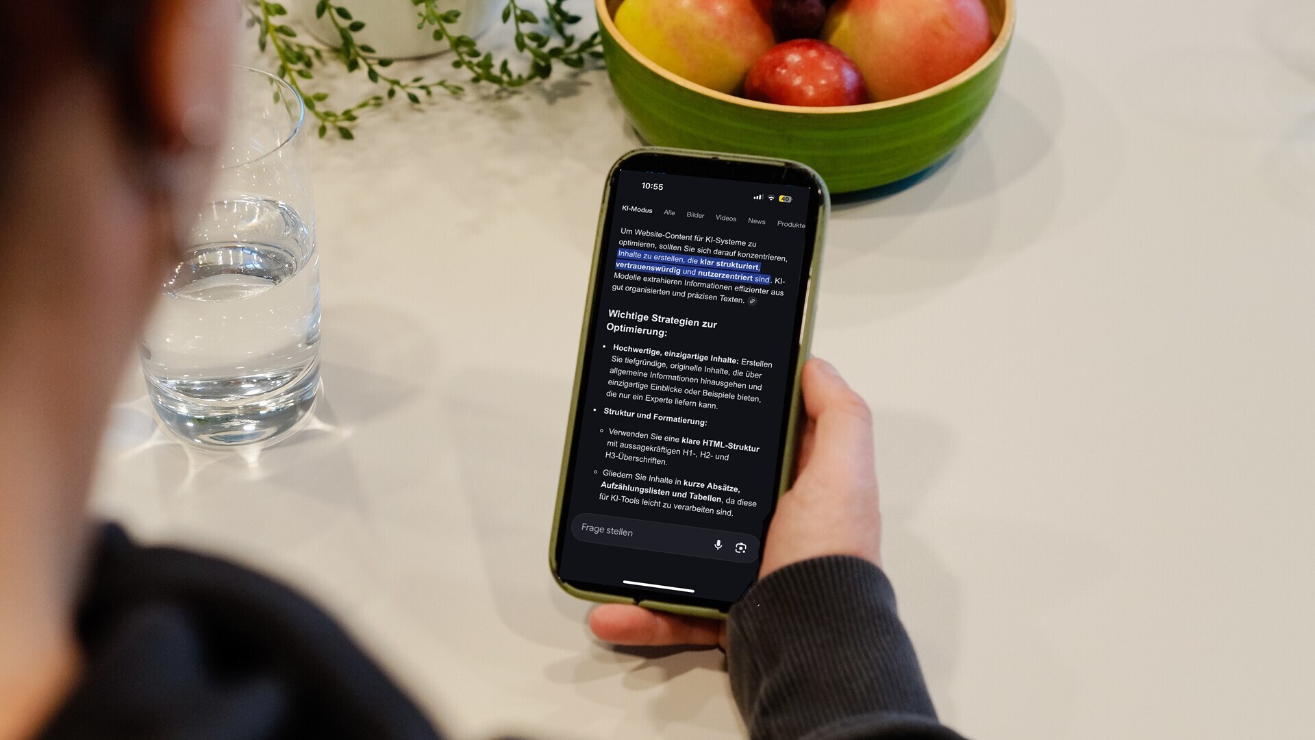 Handy-Bildschirm einer Frau mit KI-Mode auf dem Display