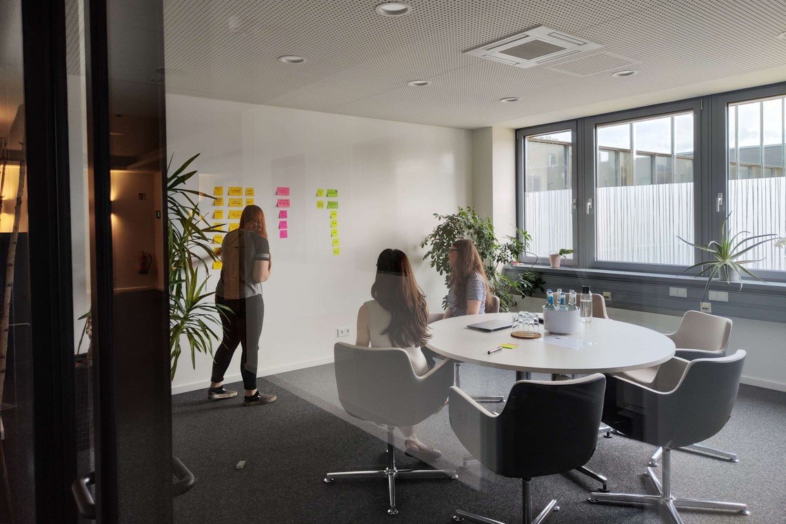 Content Marketing Agentur: drei weibliche mindshapees brainstormen mit Post-its an der Wand