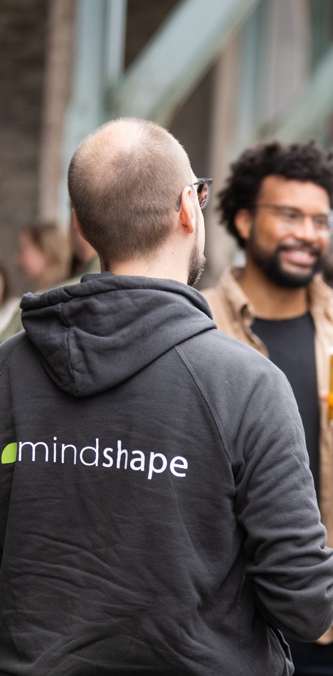 mindshape-Agenturleben: Momentaufnahme einer Person im Gespräch in einer Gruppe