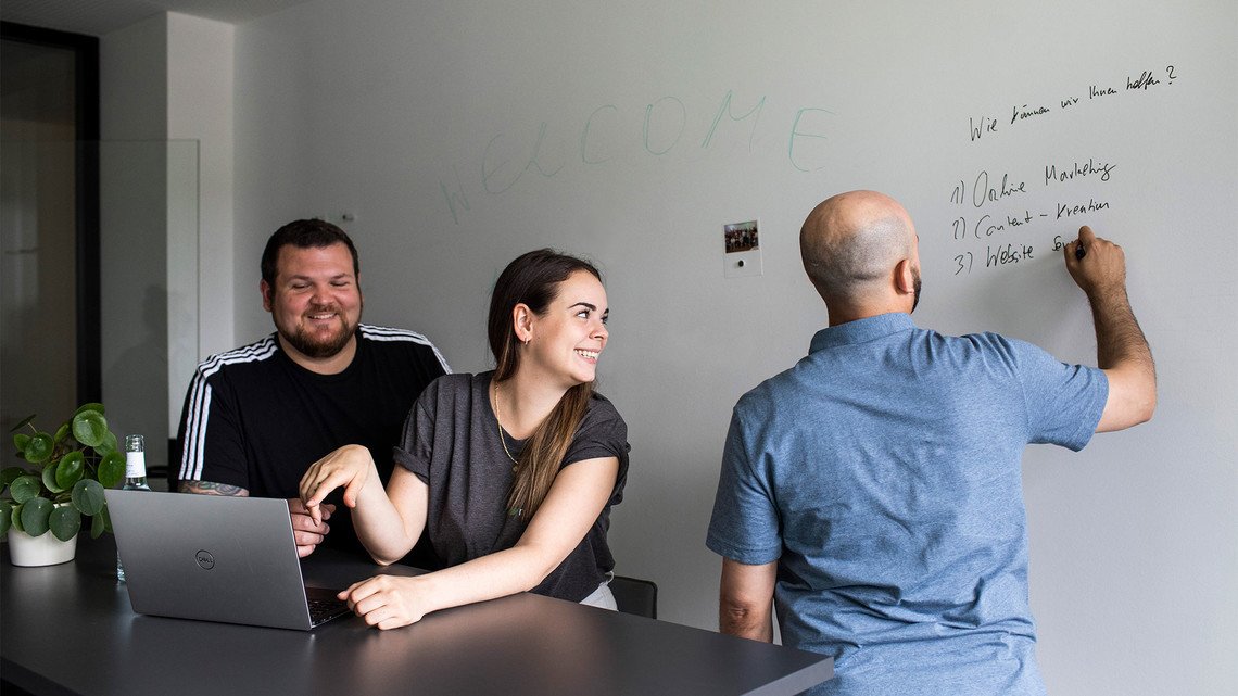 mindshape-Agenturleben: Personen im Meeting-Raum planen Inhalte an einem Whiteboard.