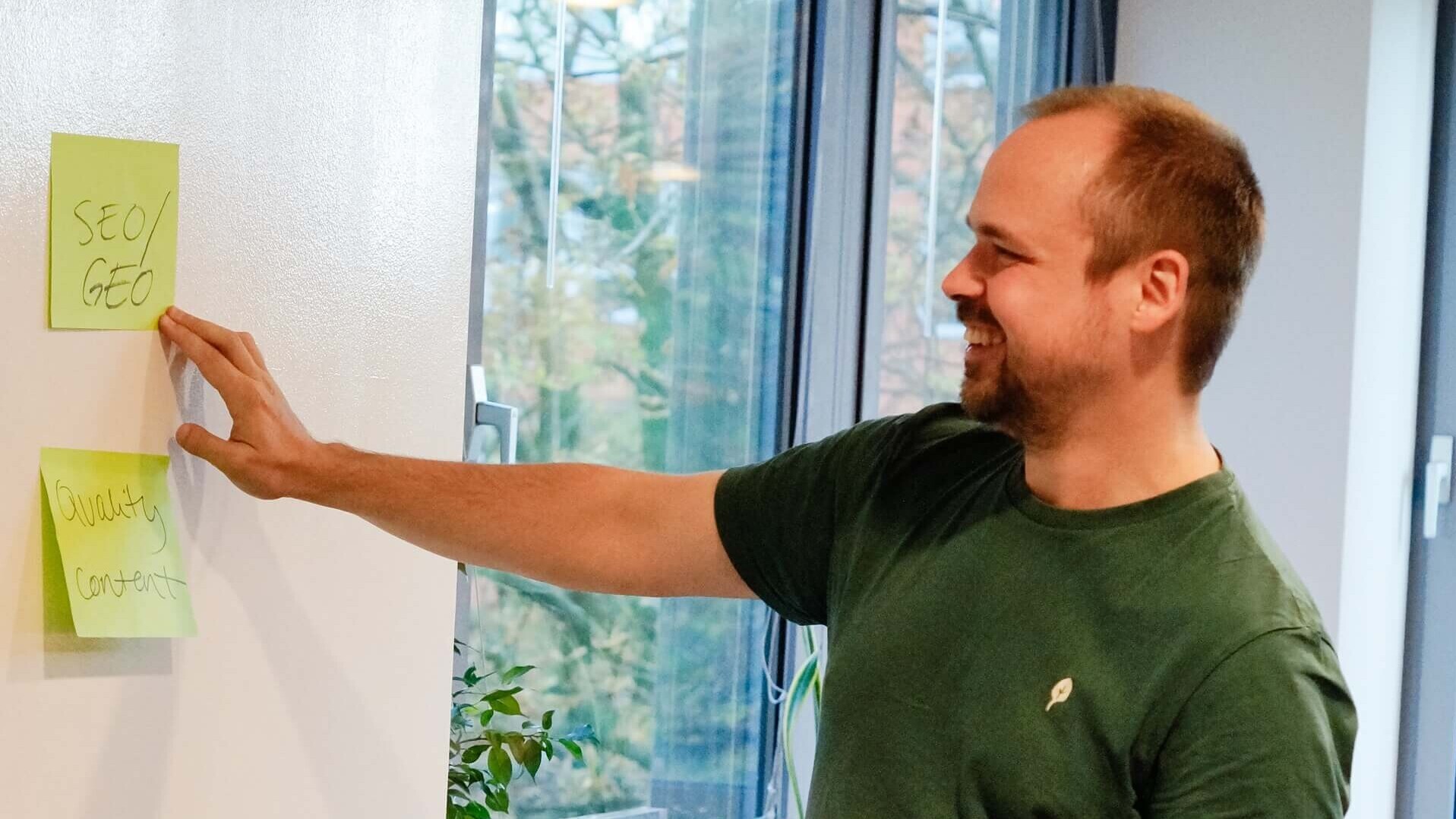 Mitarbeiter von mindshape steht am Whiteboard und zeigt auf GEO/SEO-Papier
