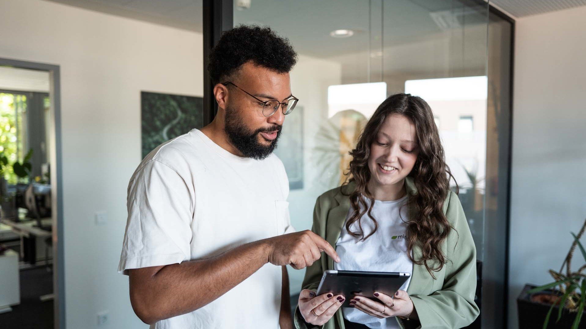 mindshape Mitarbeiter:innen lesen das Magazin auf einem Tablet