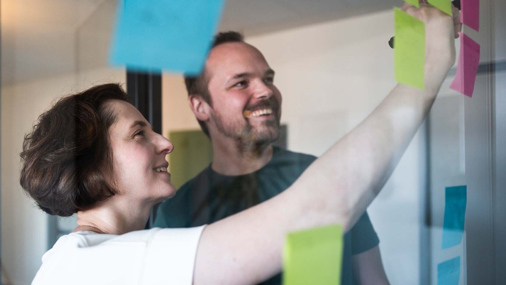 Zwei Personen brainstormen gemeinsam mit Post-its