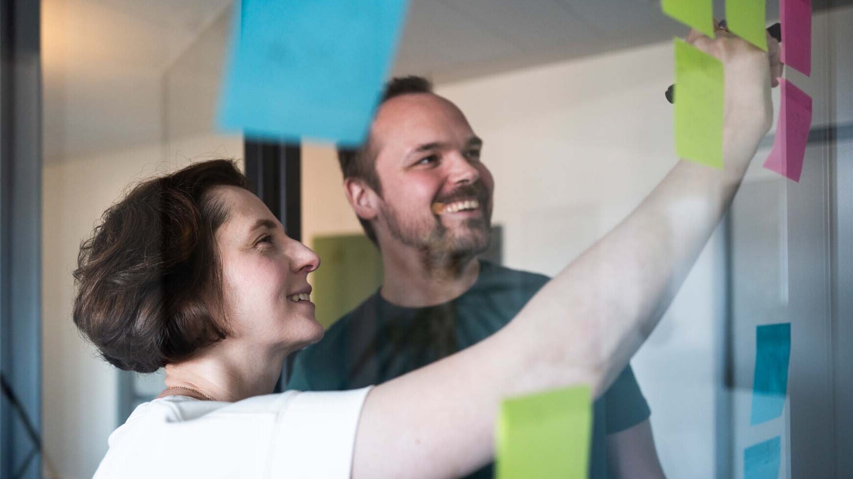 Zwei Personen bearbeiten gemeinsam Post-its