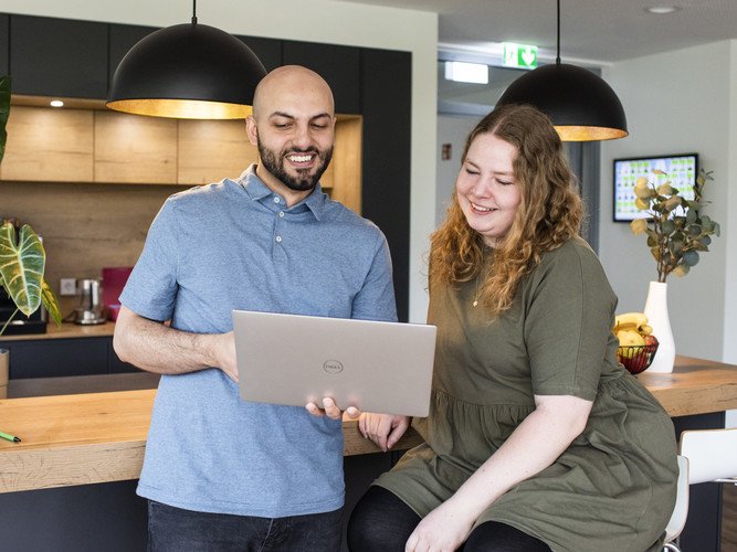 mindshape-Karriere: Zwei Personen stehen mit Laptop vor Kaffee-Theke.