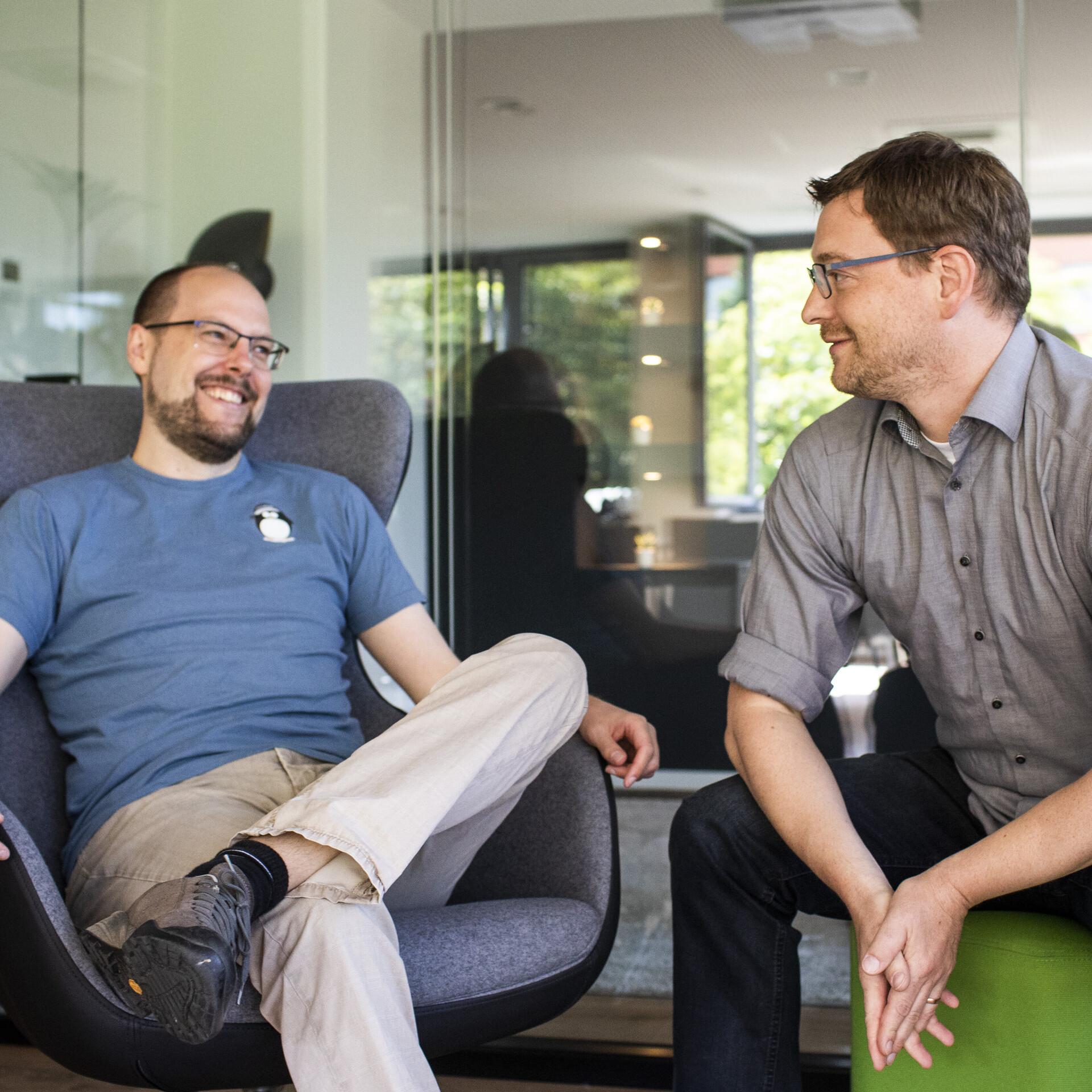 mindshape-Benefits: Geschäftsführung und Team arbeiten auf Augenhöhe. mindshape-Benefits: Momentaufnahme der beiden Geschäftsführer, die miteinander lachen.