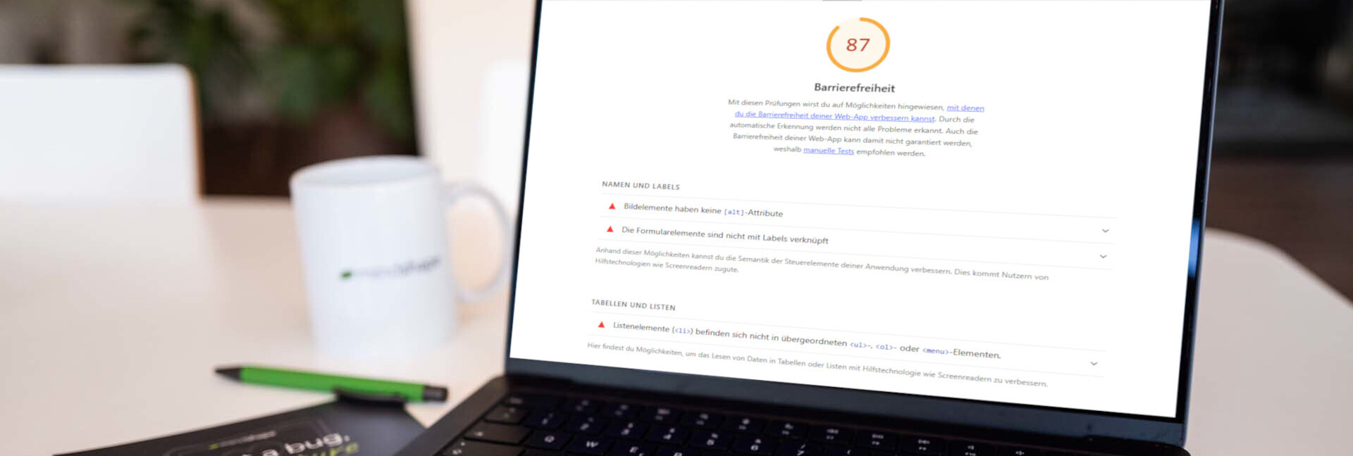 barrierefreie-websites-header Laptop mit geöffnetem Lighthouse-Report zeigt eine Barrierefreiheitsbewertung von 87 Punkten
